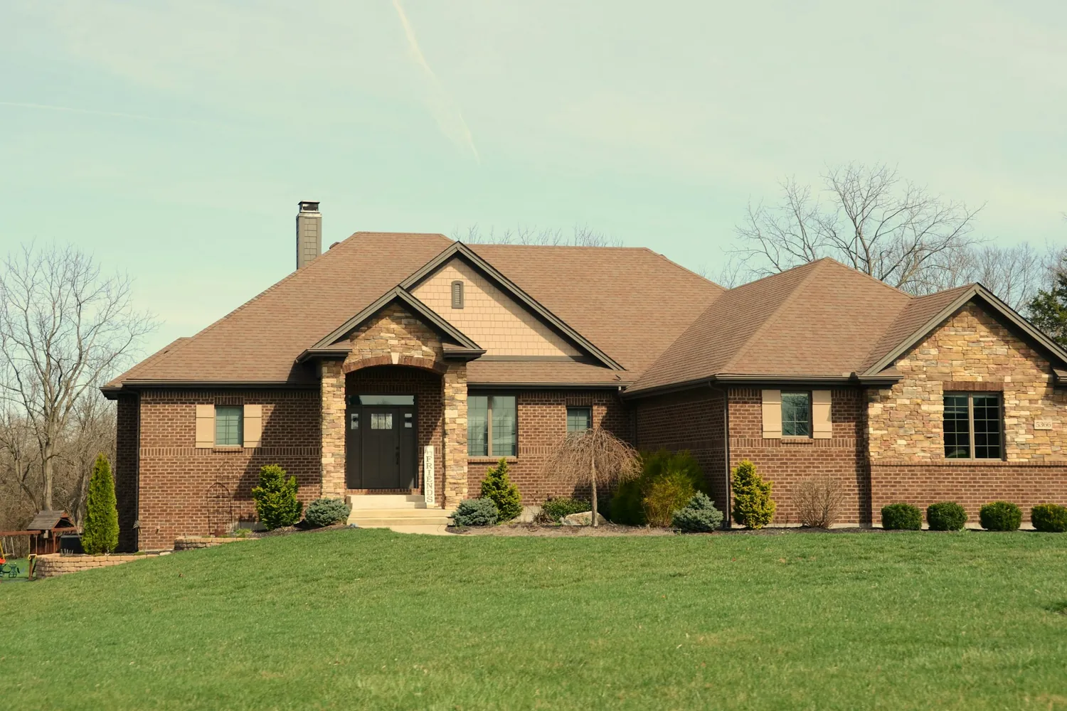 Single-story brick ranch-style home with a wide front lawn