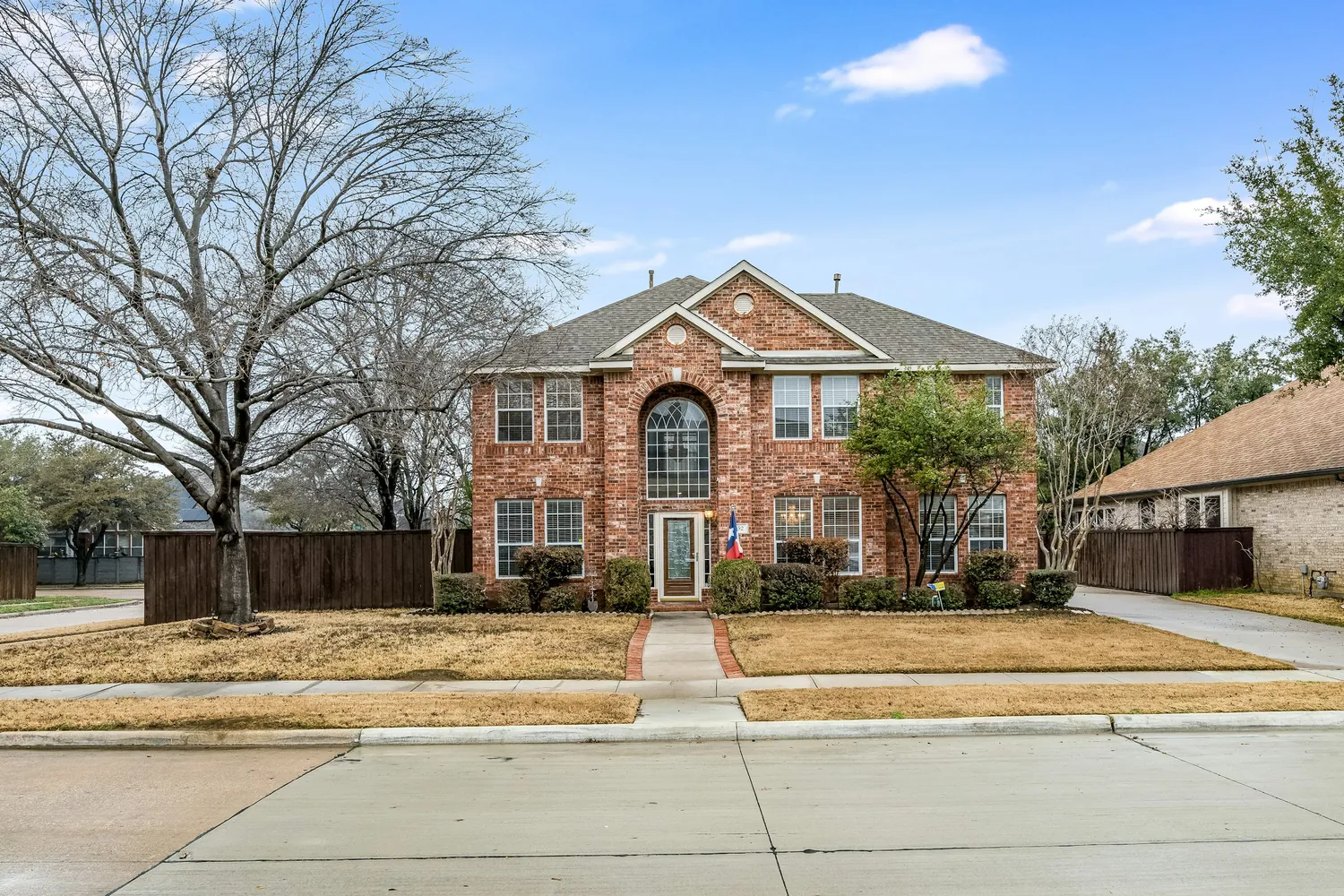 Two-story brick home with a front lawn in North Texas