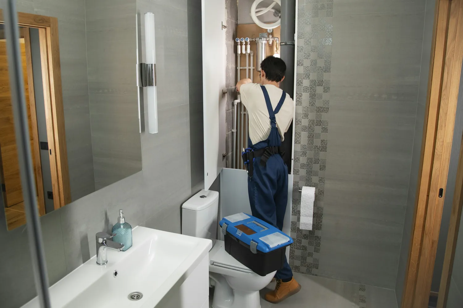Plumber with a toolbox working in a bathroom